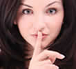 woman holding index finger to her liips as she is say shhh!